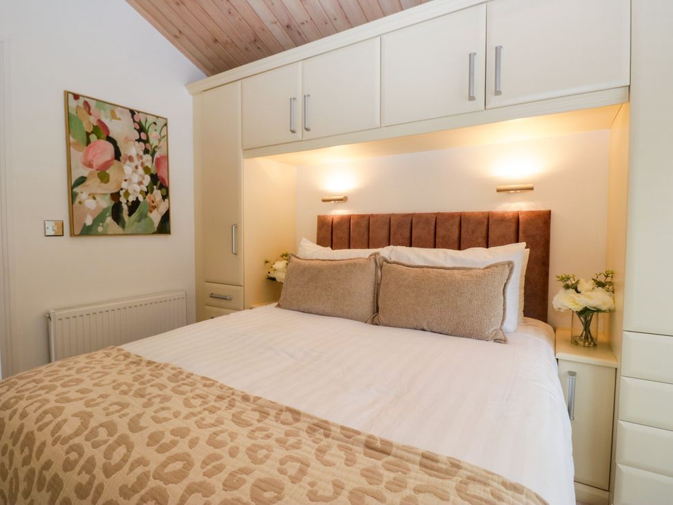 A bedroom with a bed and wall art at Fox Red Retreat in Troutbeck Bridge