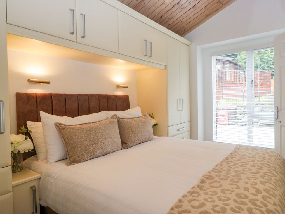A bedroom with a bed and wardrobe at Fox Red Retreat in Troutbeck Bridge