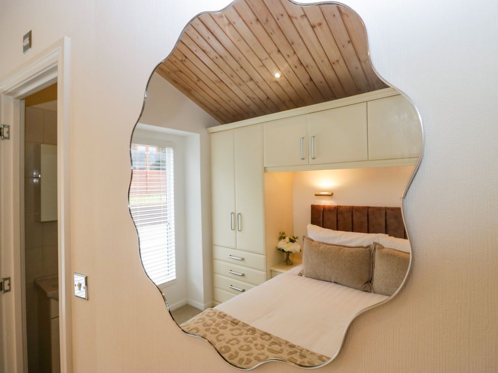 A bedroom with a bed and wardrobe at Fox Red Retreat in Troutbeck Bridge