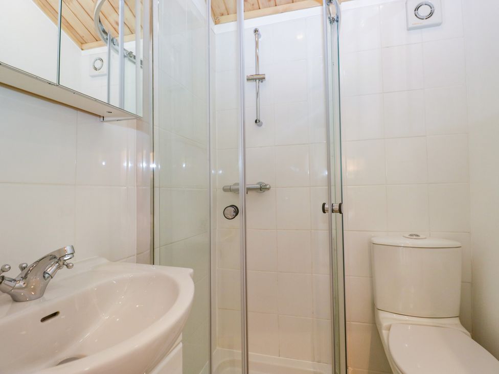 A bathroom with a shower, sink, and toilet at Fox Red Retreat in Troutbeck Bridge