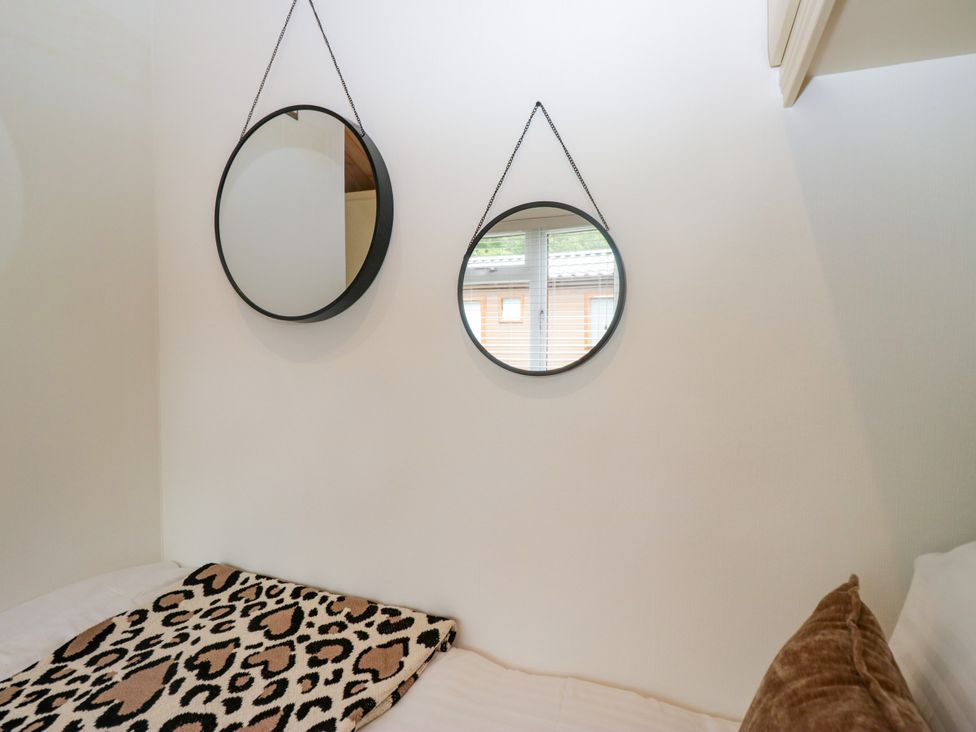 A bedroom with mirrors and a leopard print blanket at Fox Red Retreat in Troutbeck Bridge