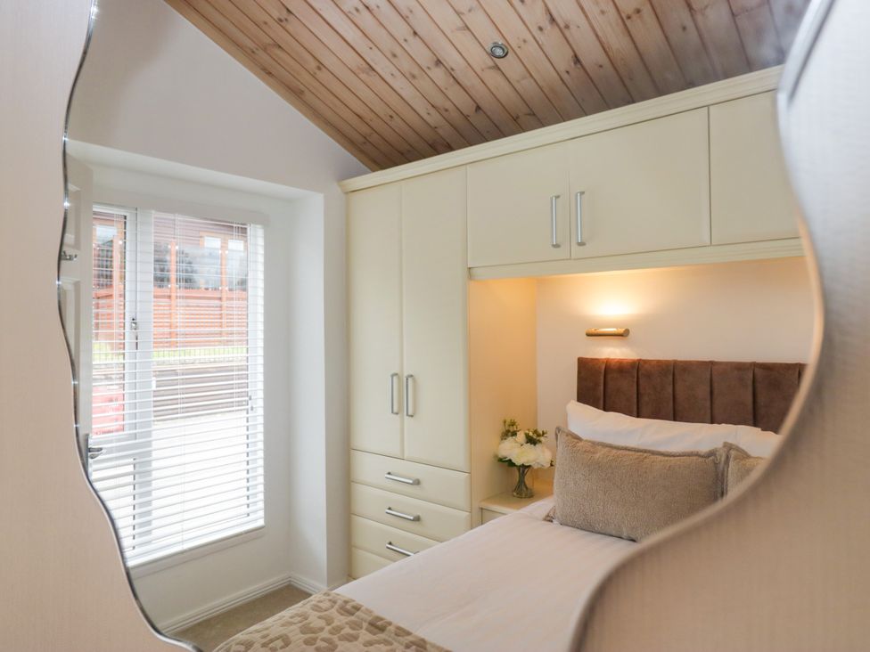 A bedroom with a bed and wardrobe at Fox Red Retreat in Troutbeck Bridge