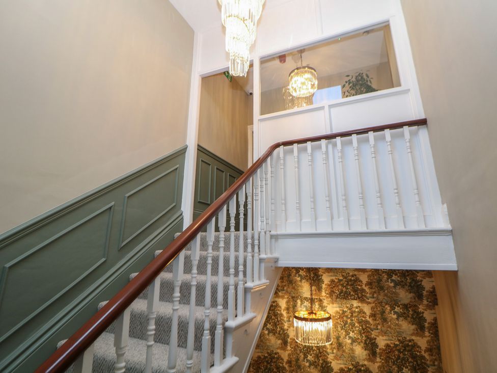 A staircase with a chandelier and decorative walls at The Loft Suite in Buxton