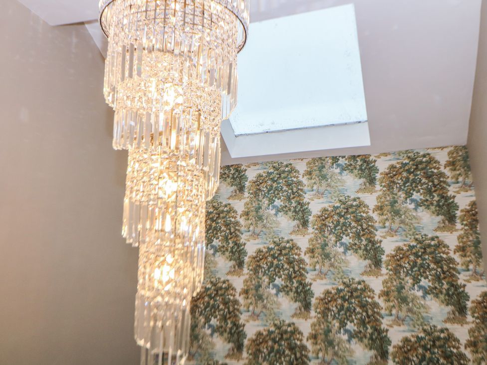 A chandelier with a skylight and wallpaper at The Loft Suite in Buxton