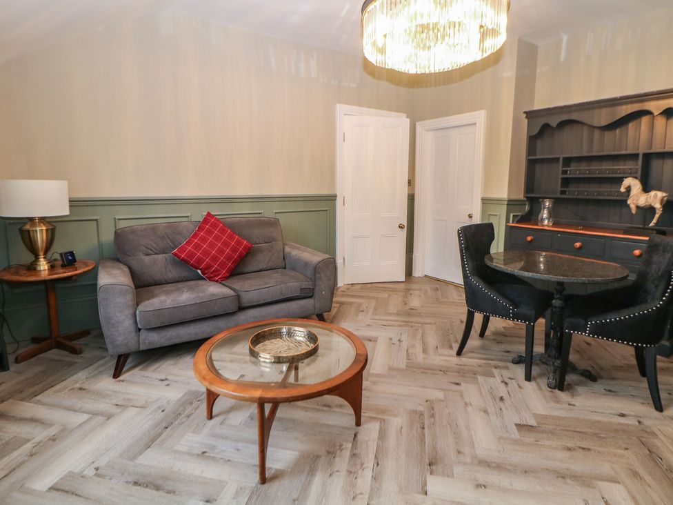 A living room with a sofa and a dining table at The Loft Suite in Buxton