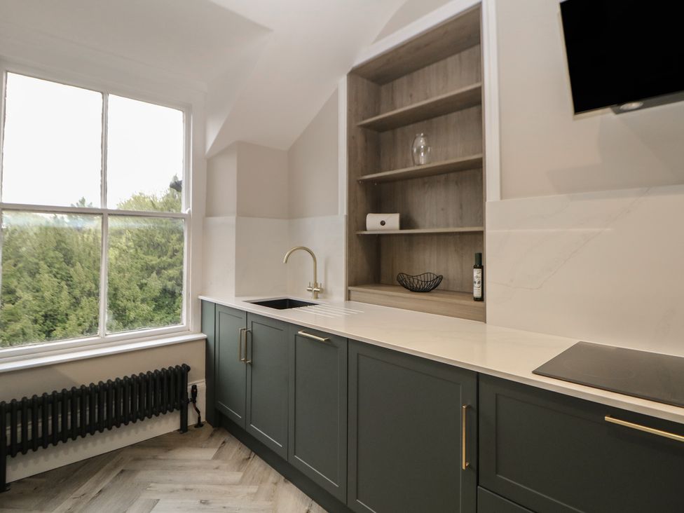 A kitchen with a sink and cabinets at The Loft Suite in Buxton