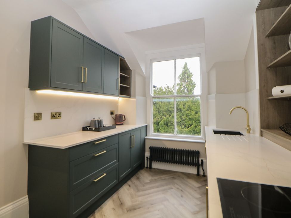 A kitchen with cabinets and appliances at The Loft Suite in Buxton