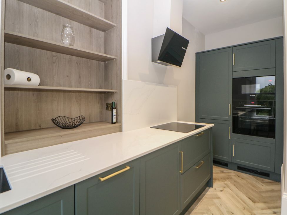 A kitchen with cabinets and appliances at The Loft Suite in Buxton
