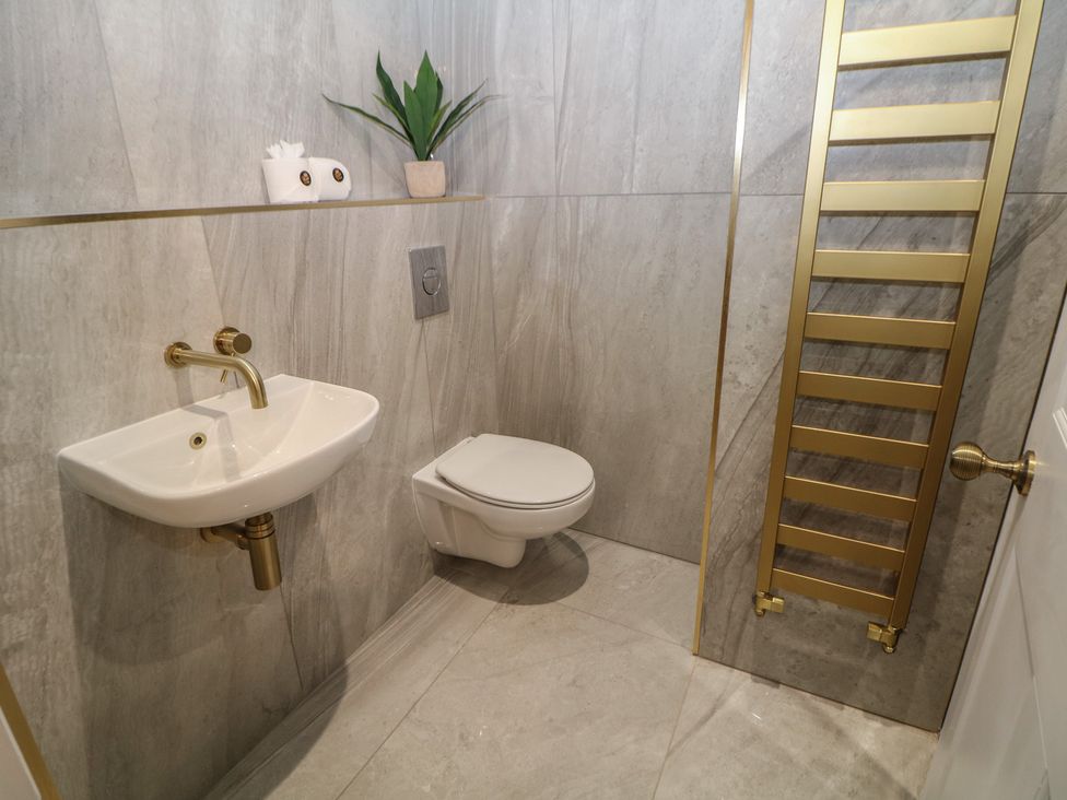 A bathroom with a sink, toilet, and towel rail at The Loft Suite in Buxton