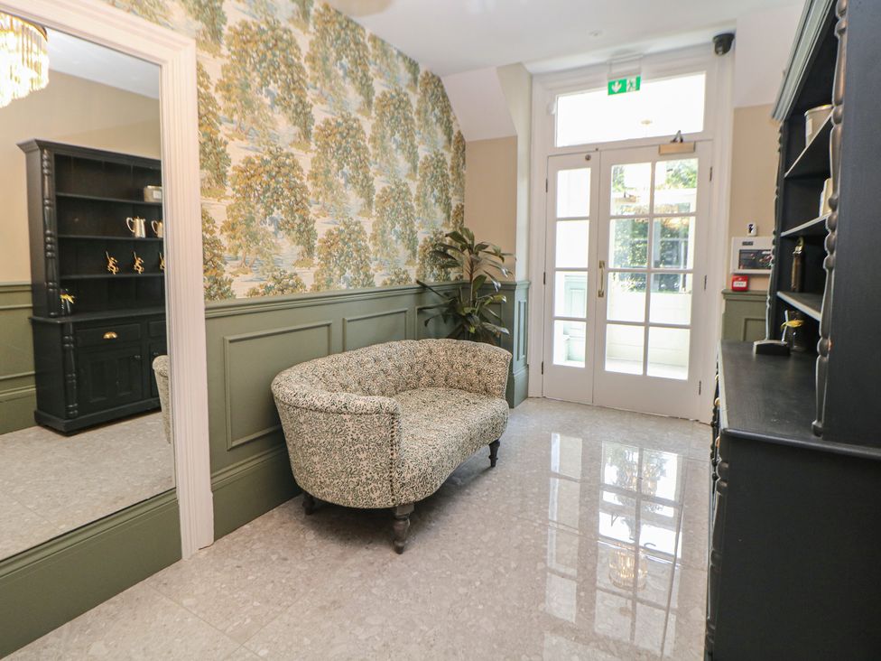 A lobby with a sofa and shelving unit at The Loft Suite in Buxton