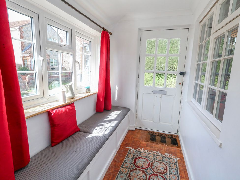 A hallway with a bench and windows at 12 West Street in Weymouth