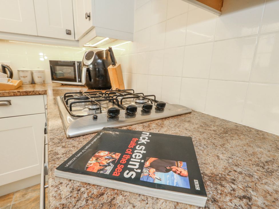 A kitchen with a gas stove and cookbook at 12 West Street in Weymouth