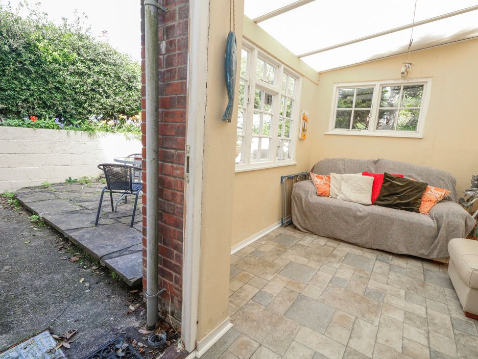 A conservatory with a sofa and table at 12 West Street in Weymouth