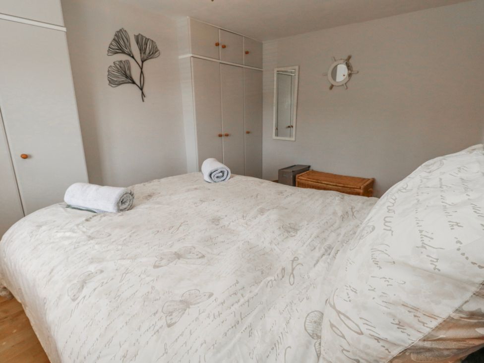 A bedroom with a bed and towels at 12 West Street in Weymouth