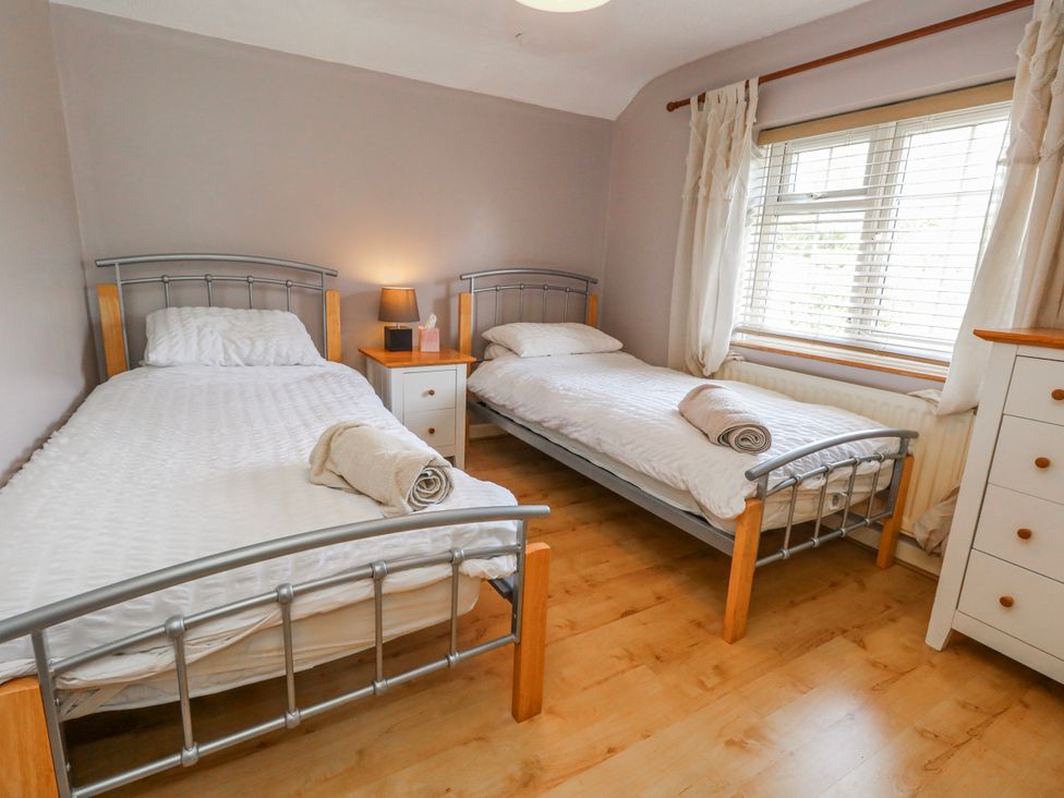 A bedroom with two single beds and a window at 12 West Street Weymouth