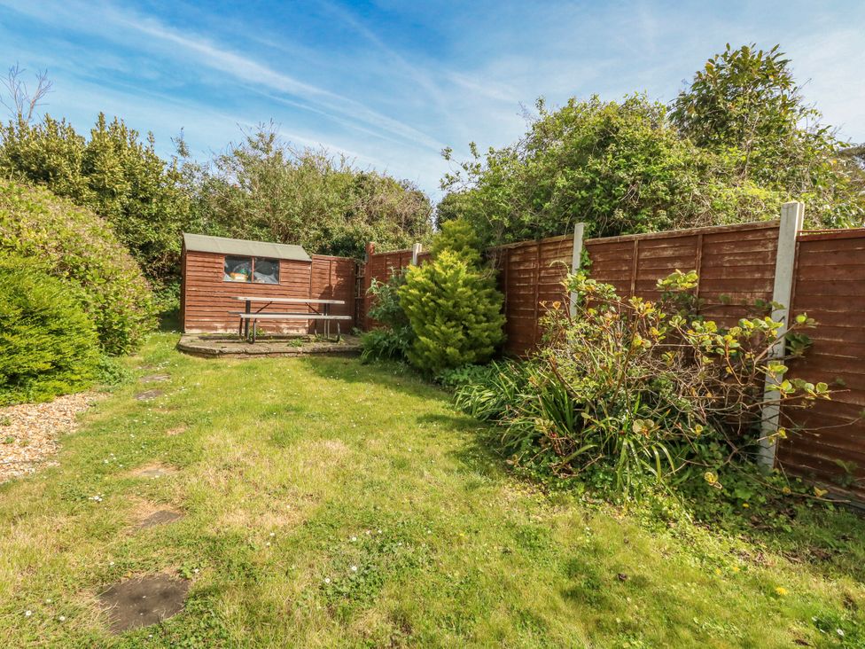 A garden with grass, a shed, and a picnic table at 12 West Street Weymouth