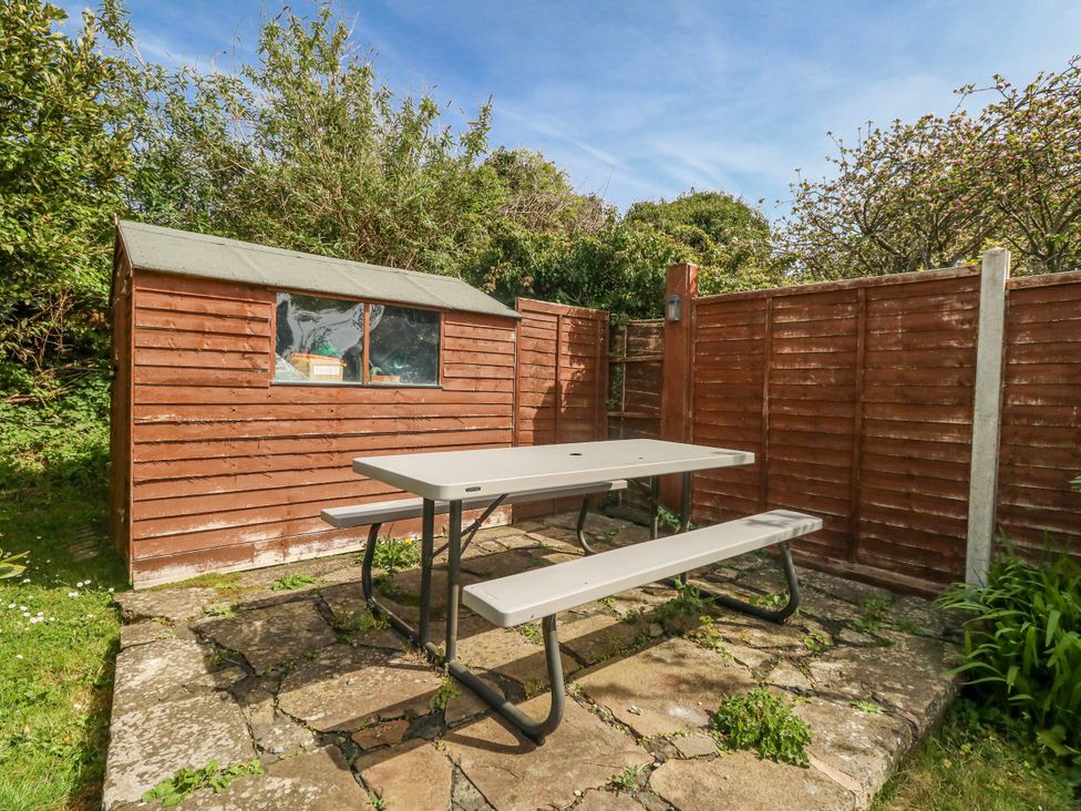 A garden with a table and benches near a shed at 12 West Street in Weymouth