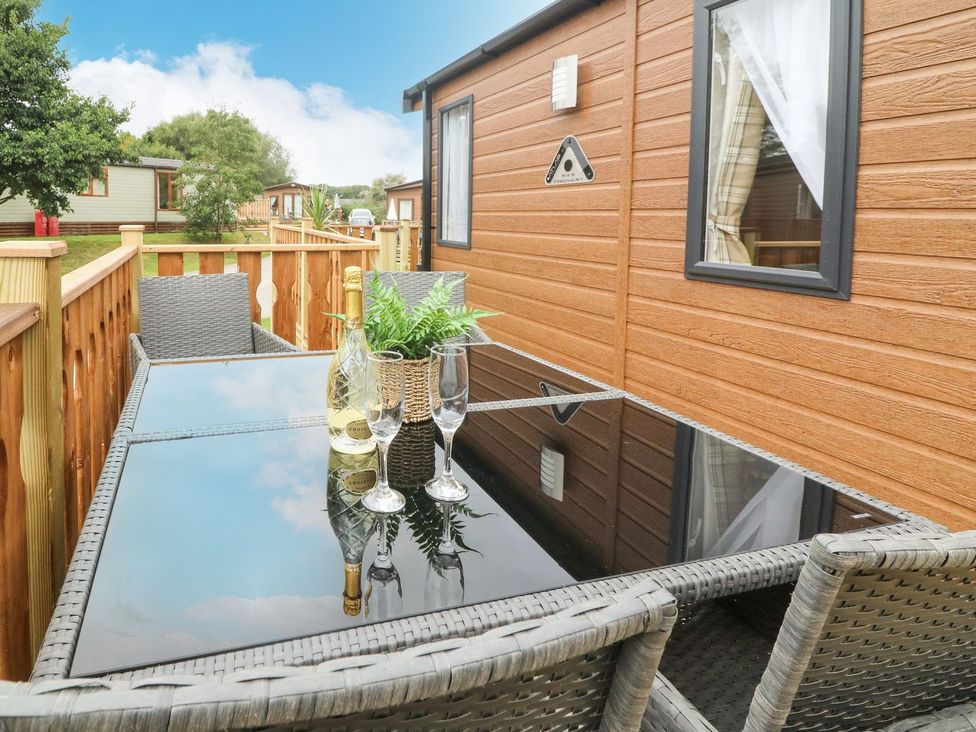 An outdoor seating area with a table and chairs at Hedgehog Lodge in Carnforth