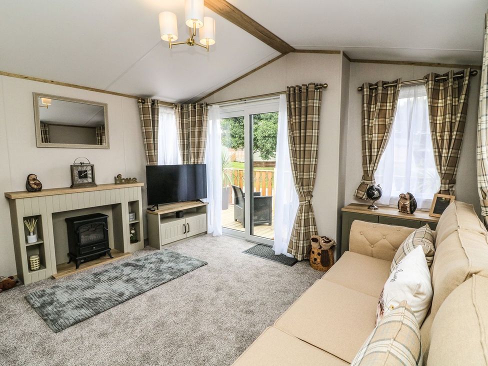 A living room with a television and a sofa at Hedgehog Lodge in Carnforth