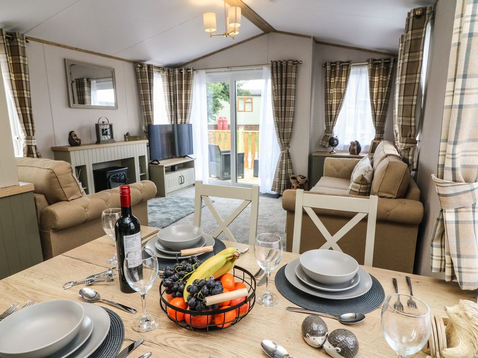 A living room with a dining table and sofa at Hedgehog Lodge in Carnforth