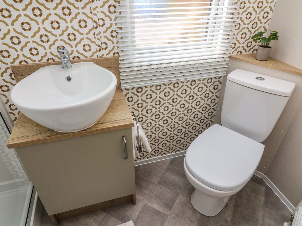 A bathroom with a sink and toilet at Hedgehog Lodge in Carnforth