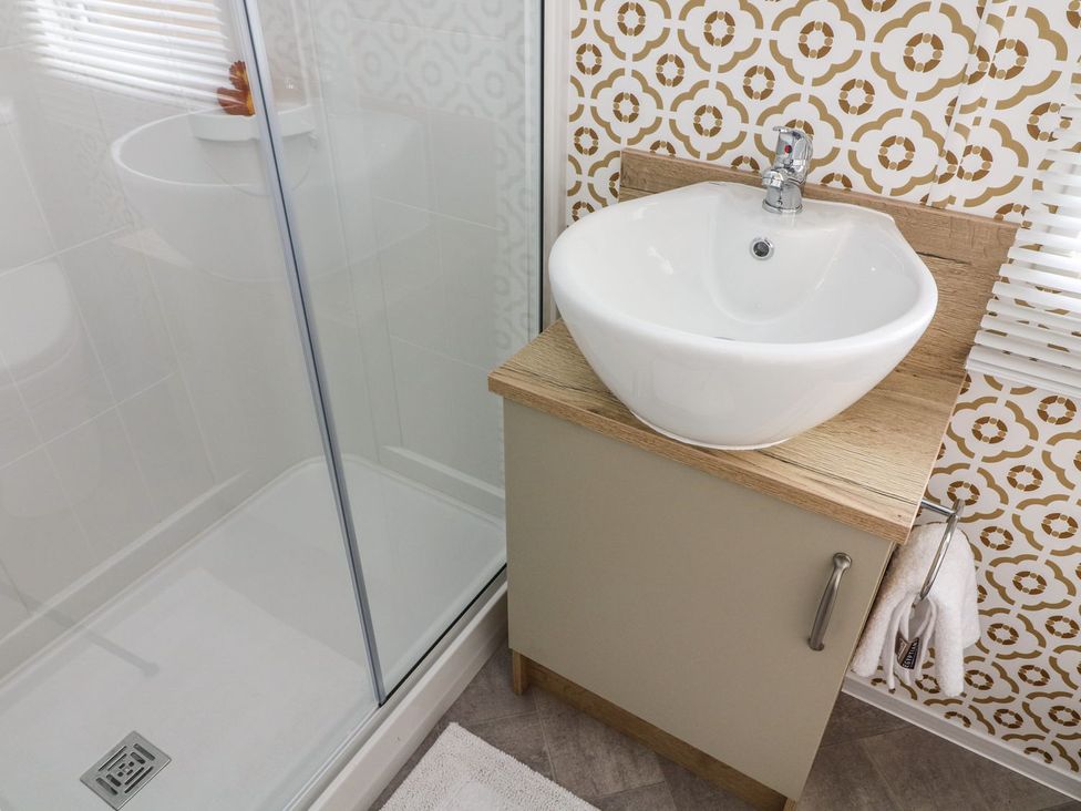 A bathroom with a sink and shower at Hedgehog Lodge in Carnforth