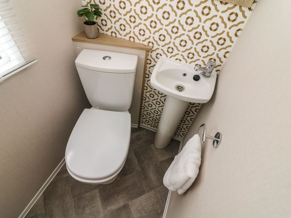 A bathroom with a toilet and a sink at Hedgehog Lodge in Carnforth
