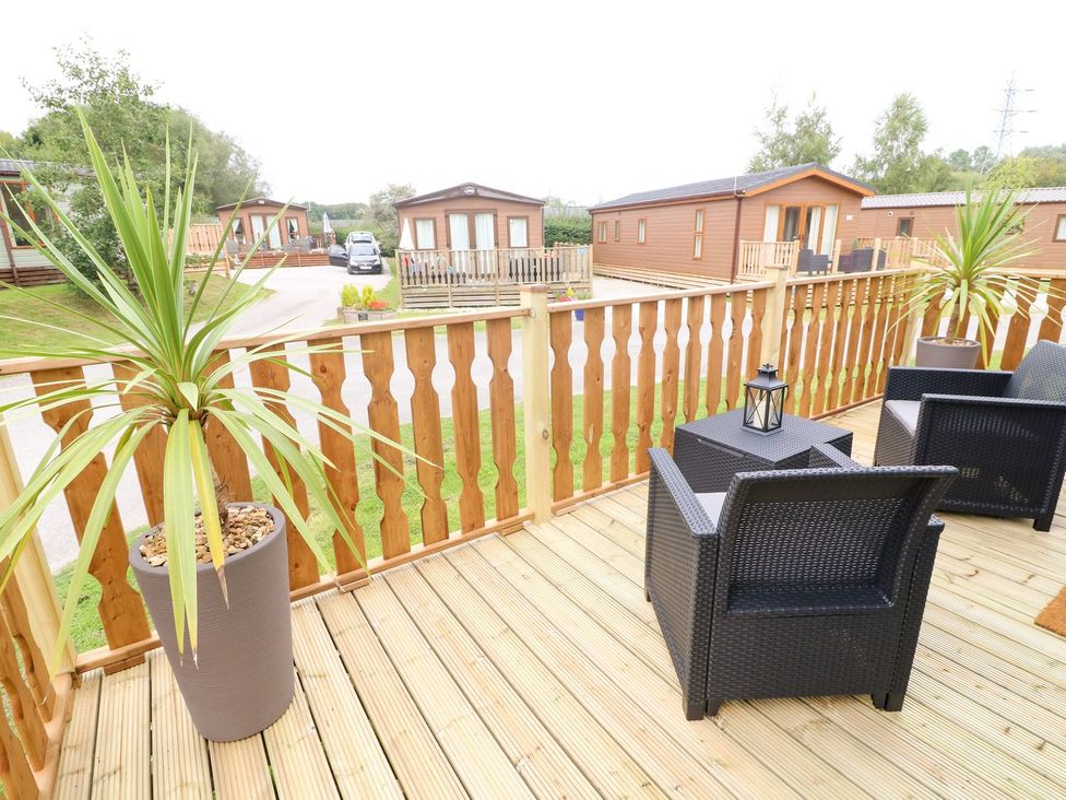 An outdoor area with chairs and a planter at Hedgehog Lodge Carnforth
