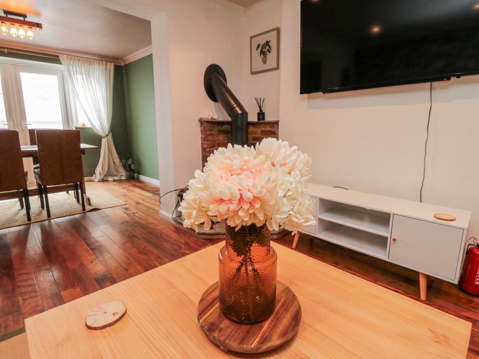 A living room with a flower vase and television at 3 Beck Mews in Scarborough
