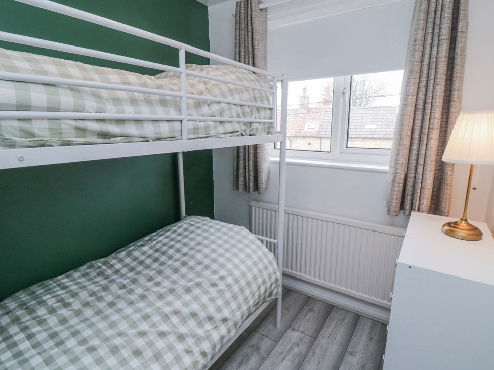 A bedroom with a bunk bed and a single bed at 3 Beck Mews Scarborough