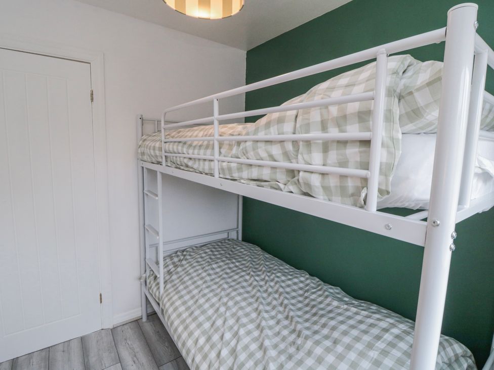 A bunk bed with green wall at 3 Beck Mews in Scarborough
