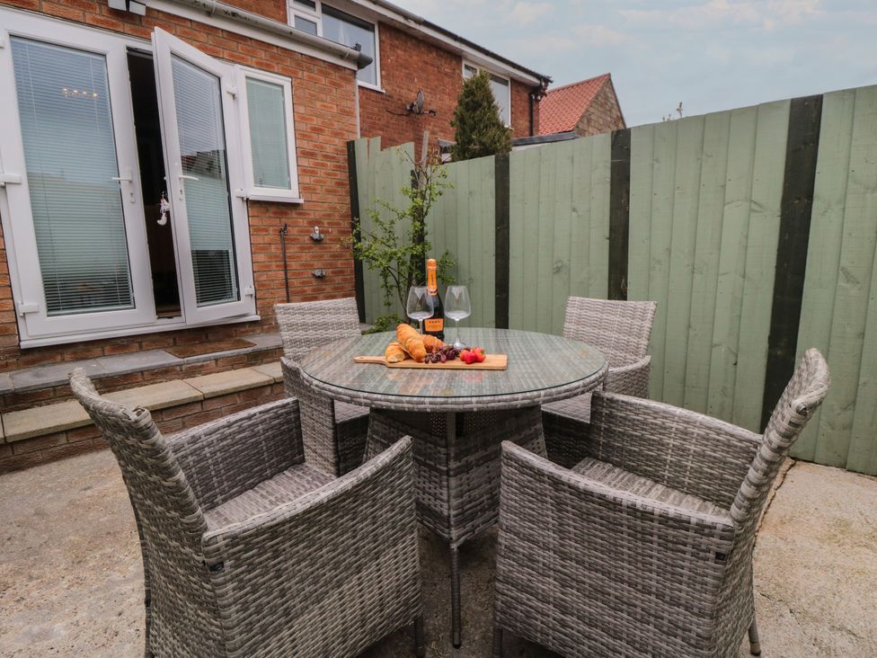 An outdoor dining area with a table and chairs at 3 Beck Mews in Cayton