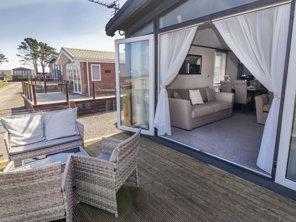 An outdoor area with seating and a view of a living room at Stone Crab Lodge in Haverfordwest
