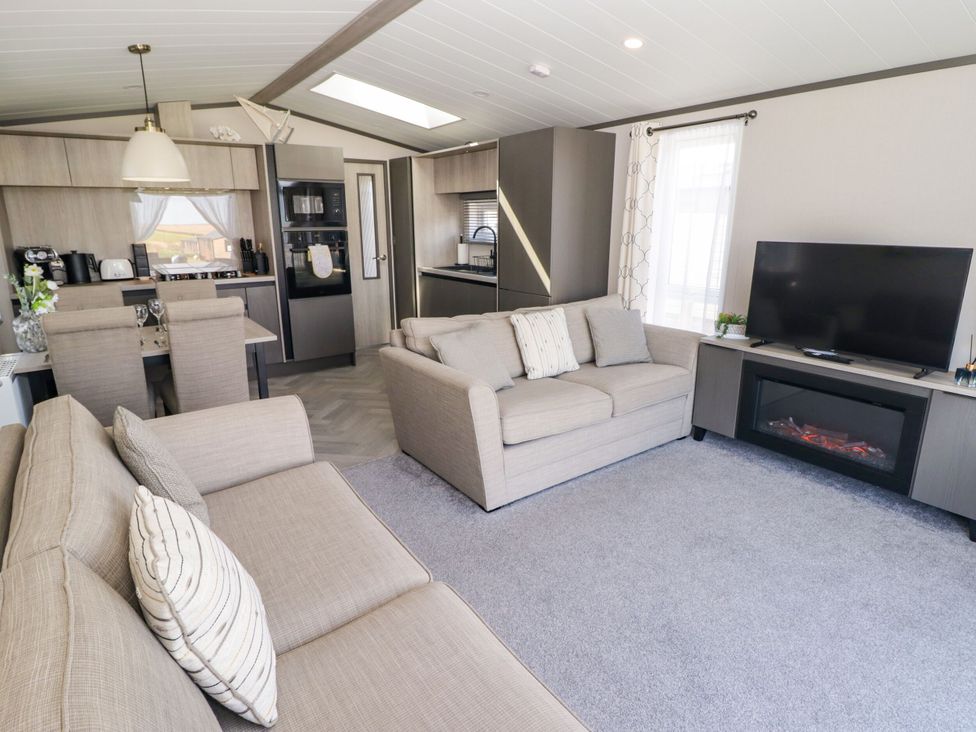 A living room with a sofa and television at Stone Crab Lodge in Haverfordwest