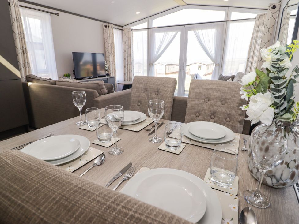 A dining room with a table set for a meal at Stone Crab Lodge in Haverfordwest