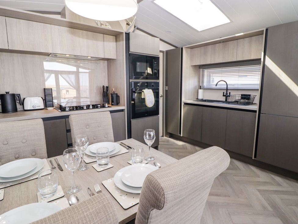 A kitchen with a dining table set for meals at Stone Crab Lodge in Haverfordwest