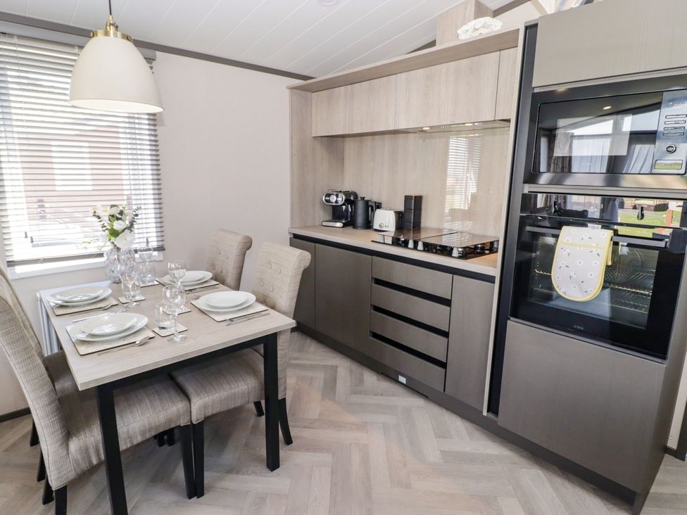 A kitchen with a dining area at Stone Crab Lodge in Haverfordwest