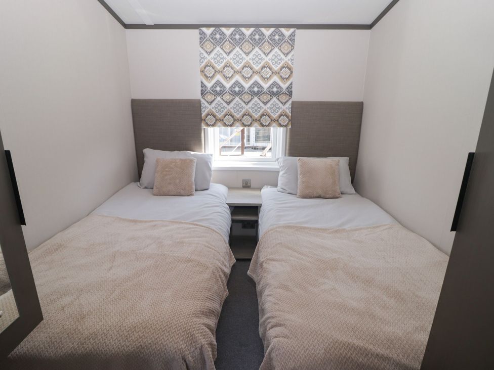 A bedroom with two beds and a window at Stone Crab Lodge in Haverfordwest
