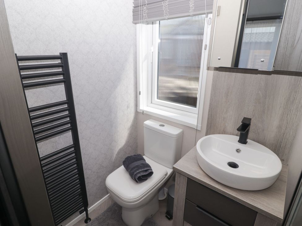 A bathroom with a toilet and sink at Stone Crab Lodge in Haverfordwest