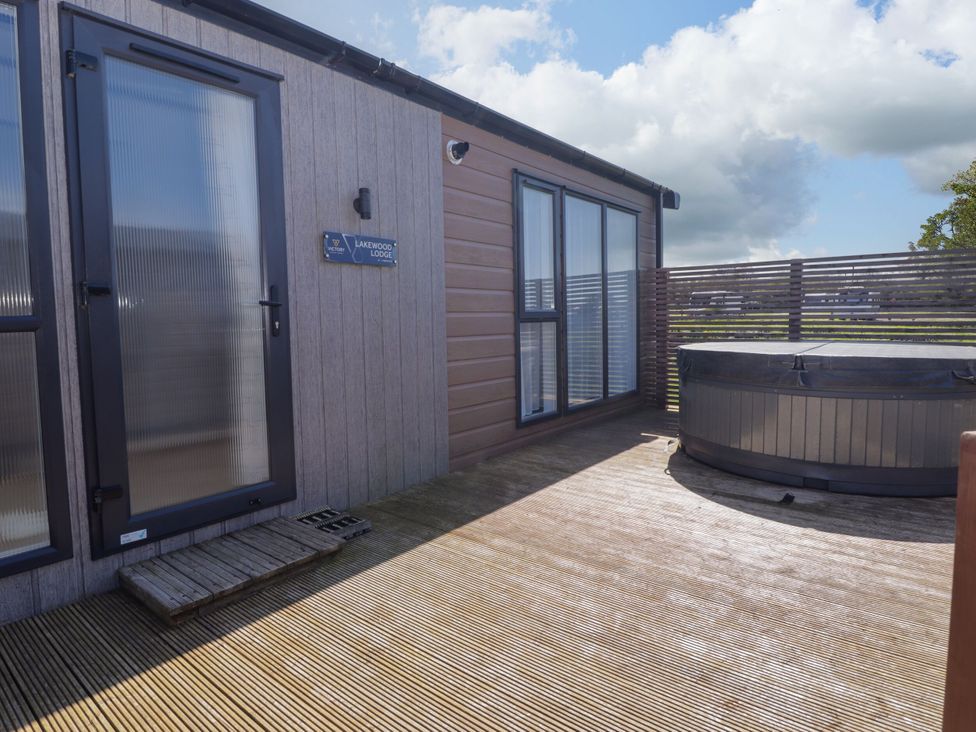 An outdoor area with a hot tub and entrance at Stone Crab Lodge in Haverfordwest