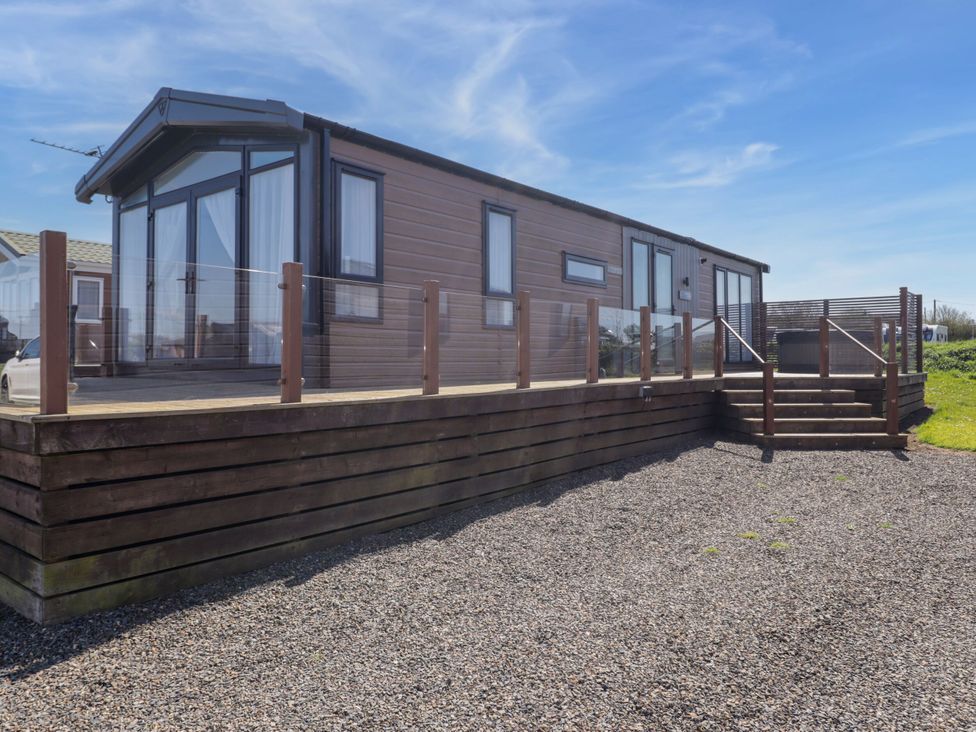 A mobile home with a deck and steps at Stone Crab Lodge in Haverfordwest