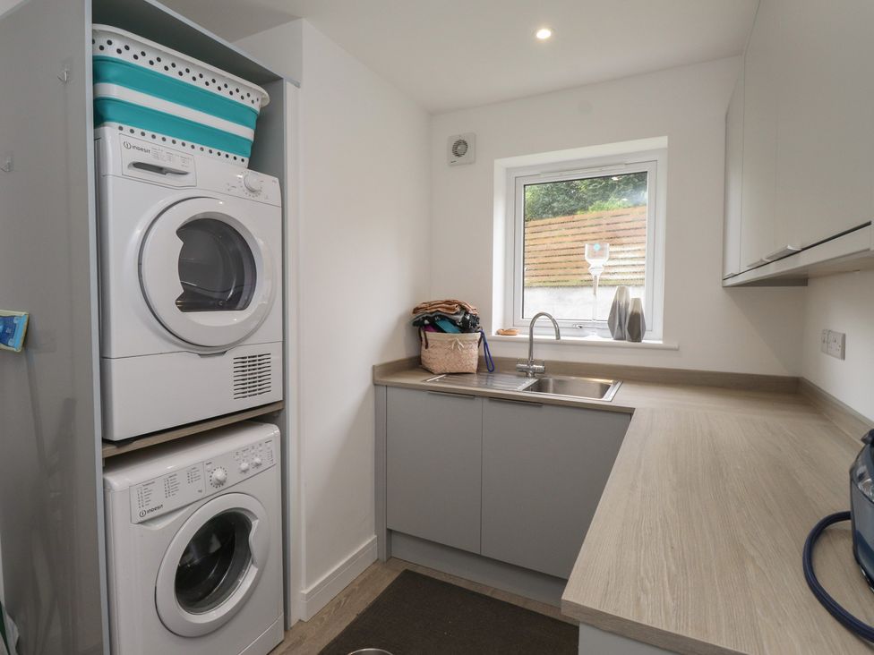 A laundry room with a washing machine and dryer at Ty Hebog
