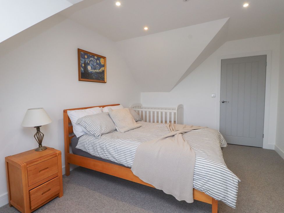 A bedroom with a bed and crib at Ty Hebog in 