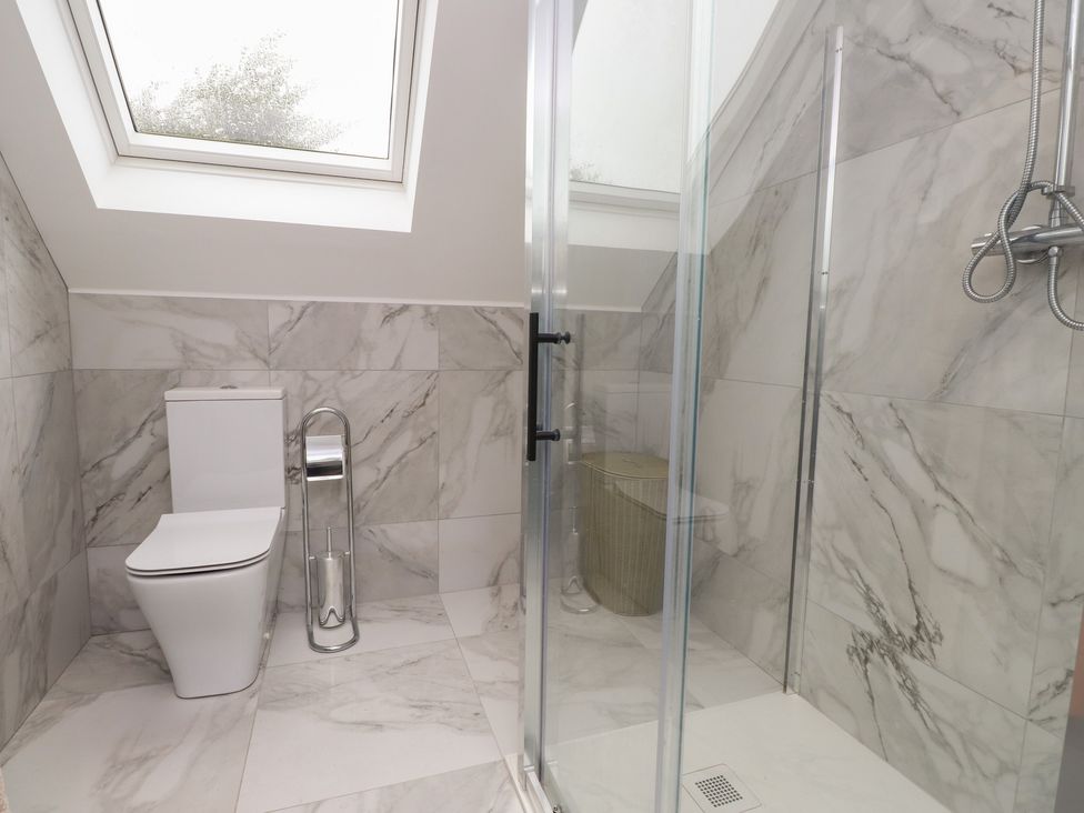 A bathroom featuring a toilet and shower at Ty Hebog