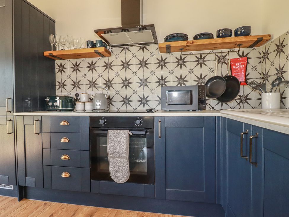 A kitchen with oven and microwave at Wisteria Lodge in Redruth
