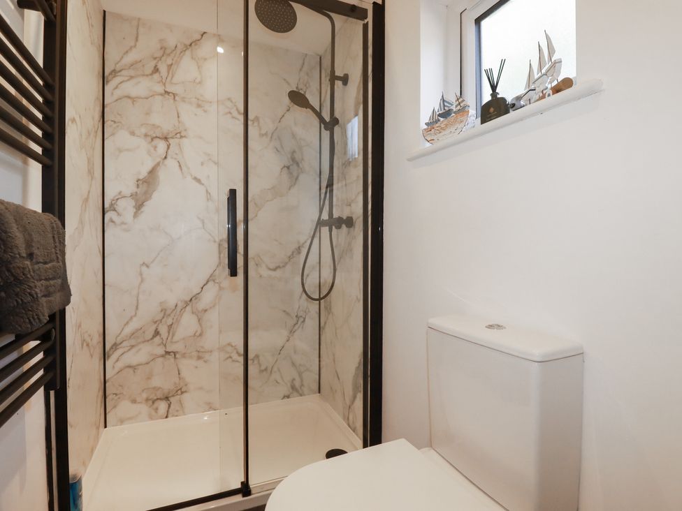 A bathroom with a shower and toilet at Wisteria Lodge in Redruth
