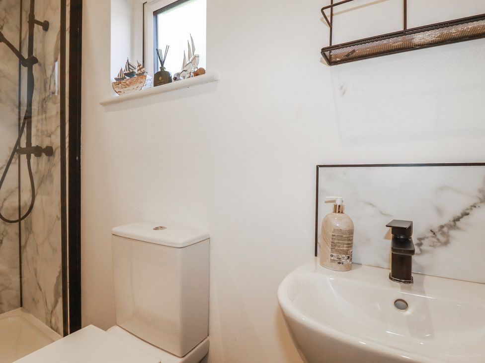 A bathroom with a shower and sink at Wisteria Lodge in Redruth