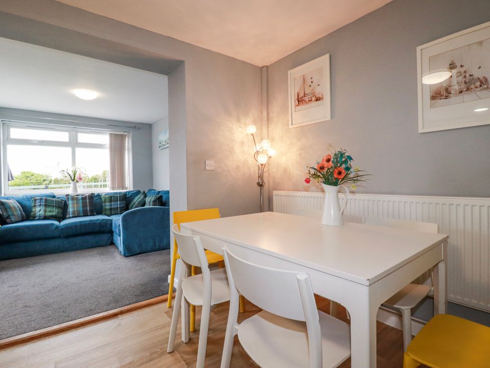 A dining room with a table and chairs at Likely Sunset in St. Austell