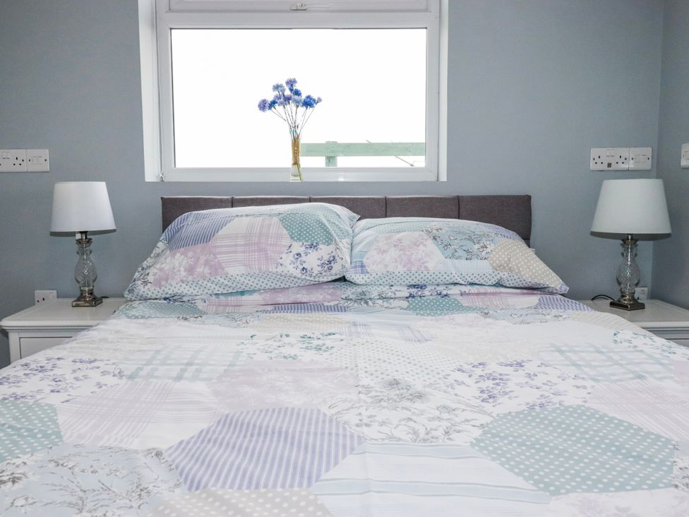 A bedroom with a bed and lamps at Likely Sunset in St. Austell