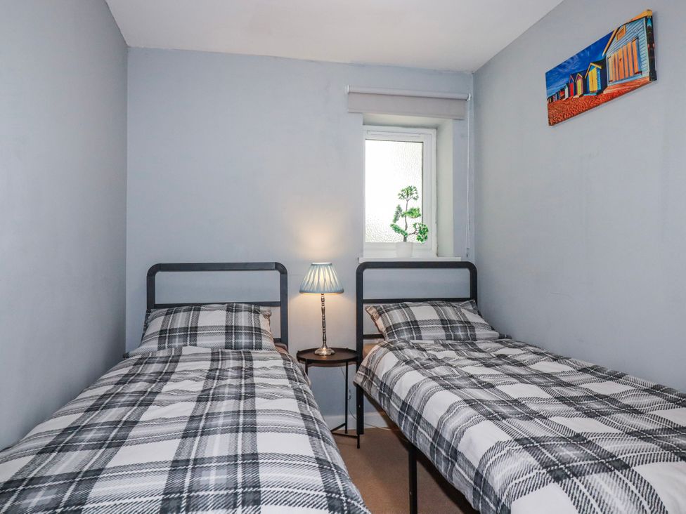 A bedroom with two beds and a lamp at Likely Sunset in St. Austell